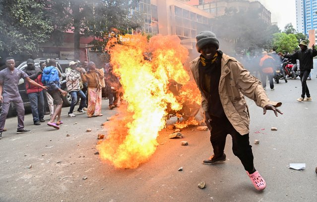 A demonnstrator reacts next to a burning motorcycle, on the day of a protest over the death of Kenyan blogger Albert Ojwang in police custody, in downtown Nairobi, Kenya on June 17, 2025. (Photo by John Muchucha/Reuters)
