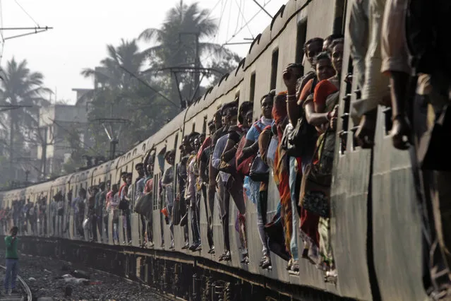 Indian commuters travel in a local train in Kolkata, India, Tuesday, Feb. 26, 2013. Indian Railway Minister Pawan Kumar Bansal is presenting the country's rail budget for next fiscal year in the parliament Tuesday, Feb. 26, 2013. Indian railway network is one of the world's largest, with some 14 million passengers daily and some 64,000 kilometers (40,000 miles) of railway track cut through some of the most densely populated cities. (Photo by Bikas Das/AP Photo)