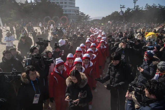 North Korean cheerleaders are surrounded by media as they attempt to walk on Gyeongpo beach in Gangneung on February 13, 2018. (Photo by Ed Jones/AFP Photo)