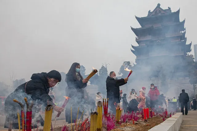 People wear masks as they pray for the Spring Festival  at the Guiyuan temple on January 22, 2023 in Wuhan, Hubei Province, China. China is marking the Spring Festival which begins with the Lunar New Year on January 22, ushering in the Year of the rabbit. (Photo by Getty Images)