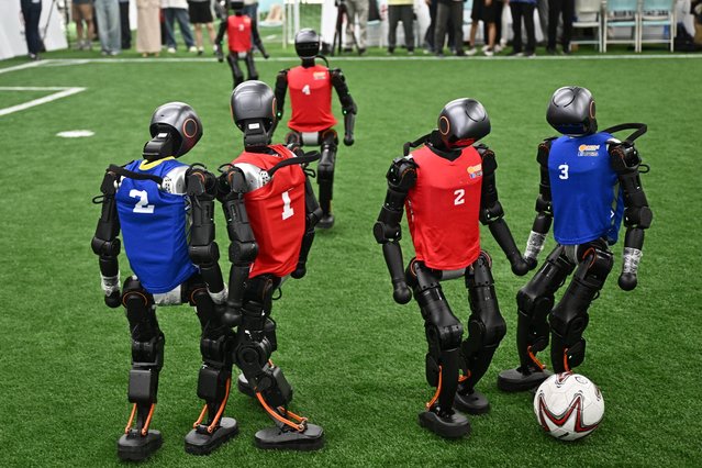 Humanoid robots vie for the ball during an exhibition football match ahead of the World Humanoid Robot Games in Beijing on August 4, 2025. Beijing will host the World Humanoid Robot Games from August 15 to 17. (Photo by Pedro Pardo/AFP Photo)