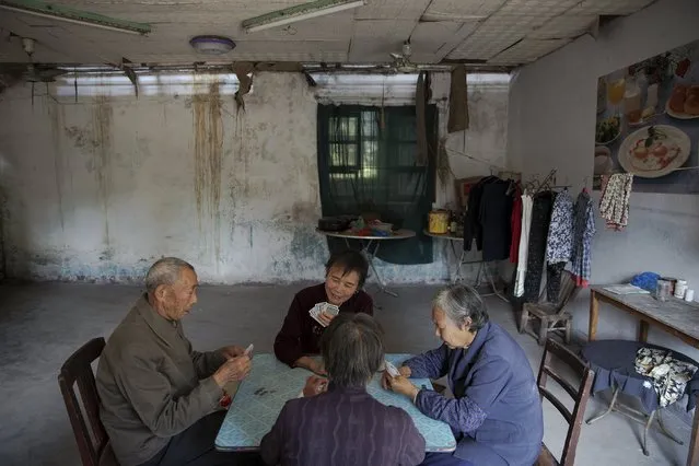Patients and their relatives play cards in a dilapidated service building at Yangjia Hospital in Wuyi County, Zhejiang Province, China October 19, 2015. (Photo by Damir Sagolj/Reuters)