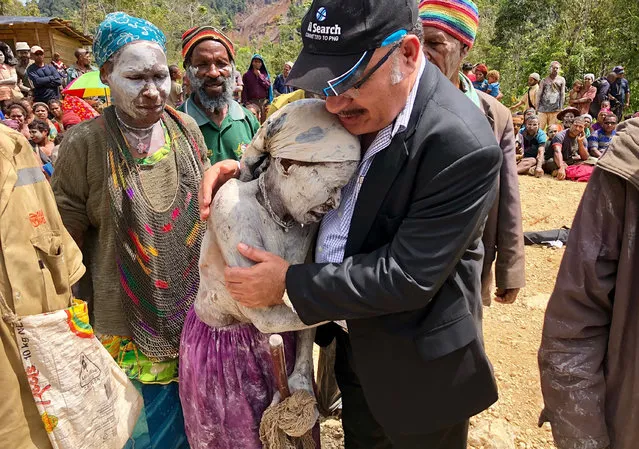In this handout photo from the prime minister' s office taken on March 7, 2018 Prime Minister of Papua New Guinea, Peter O' Neill (R) comforts a villager in Tari, in Hela province after an earthquake hit the remote area in the highlands of Papua New Guinea. The death toll from the earthquake has topped 100 with thousands injured, and O' Neill, warned on March 9, 2018 that it will take years for the region to recover after. the Pacific nation' s mountainous interior was struck by a 7.5- magnitude tremor on February 26, triggering landslides that blocked roads, caused power outages and cut- off villages. (Photo by AFP Photo/Prime Ministers Office)