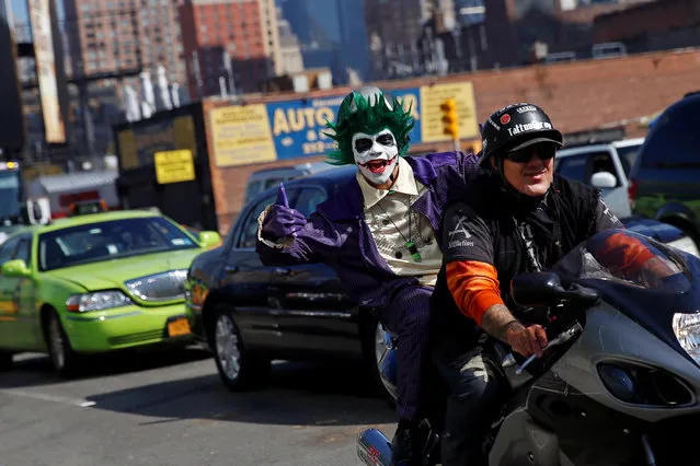 A man dressed in costume gives the thumbs up while riding on a motorcycle enroute to the New York Comic Con with other commuters in New York, U.S., October 6, 2016. (Photo by Shannon Stapleton/Reuters)