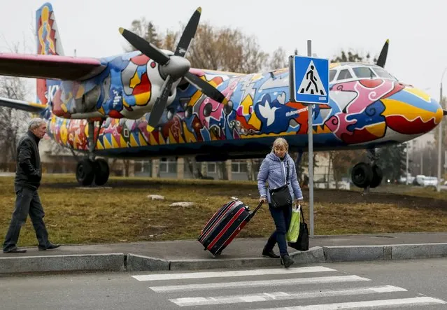 People pass near by a painted Antonov-24 plane at Zhulyany airport in Kiev, Ukraine, November 5, 2015. (Photo by Gleb Garanich/Reuters)