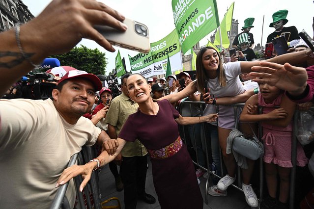 Mexico's presidential candidate for the ruling Morena party Claudia Sheinbaum poses for pictures with supporters as she arrives to her campaign closing rally, at the Zocalo square in Mexico City on May 29, 2024. Mexico will hold general election on June 2 and its next president will face an array of challenges, including managing migration, delicate relations with the neighboring United States and criminal violence that has left more than 450,000 people dead and tens of thousands missing since 2006. (Photo by Pedro Pardo/AFP Photo)