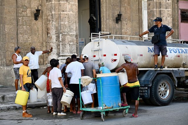 Cubans wait to fill their water containers from a water truck in Havana on September 29, 2025. (Photo by Yamil Lage/AFP Photo)