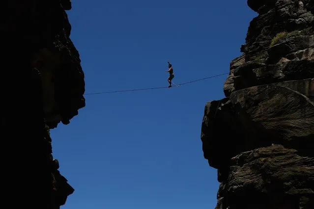 Matt Macelli walks along a slackline as he highlines between two cliffs on December 21, 2014 in Sydney, Australia. (Photo by Cameron Spencer/Getty Images)