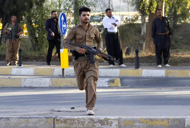 A member of peshmerga forces runs at a site of an attack by Islamic State militants in Kirkuk, Iraq, October 21, 2016. (Photo by Ako Rasheed/Reuters)