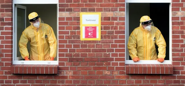 Two soldiers of the German armed forces wait at a corona test center for people to have a corona test in Pasewalk, eastern Germany, Friday, December 18, 2020. Word reads “test window”. (Photo by Stefan Sauer/dpa via AP Photo)