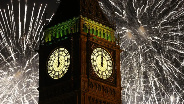 Fireworks explode over the clock known as “Big Ben” housed in Elizabeth Tower, to celebrate the New Year in London, Thursday, January 1, 2015. (Photo by Kirsty Wigglesworth/AP Photo)