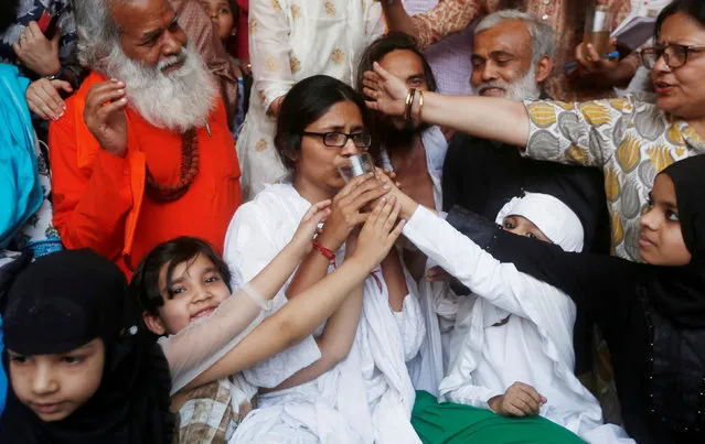 Girls offer juice to Swati Maliwal, chairperson of Delhi Commission for Women, to end her fast during her hunger strike protest demanding stricter laws for rape in India, in New Delhi, India, April 22, 2018. (Photo by Adnan Abidi/Reuters)