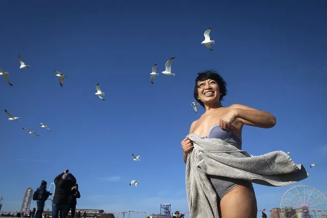 Ke Qin Yang wraps herself in a bathrobe after taking part in the Polar Bear Plunge on Coney Island in the Brooklyn borough of New York January 1, 2015. The Coney Island Polar Bear Club is one of the oldest winter bathing organizations in the United States and holds a New Year's Day plunge every year. (Photo by Carlo Allegri/Reuters)