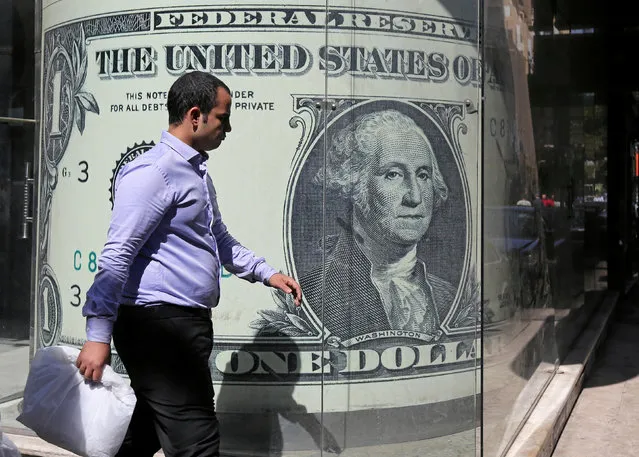 A man walks past a currency exchange bureau advertisement showing an image of the U.S. dollar in Cairo, Egypt October 13, 2016. (Photo by Mohamed Abd El Ghany/Reuters)
