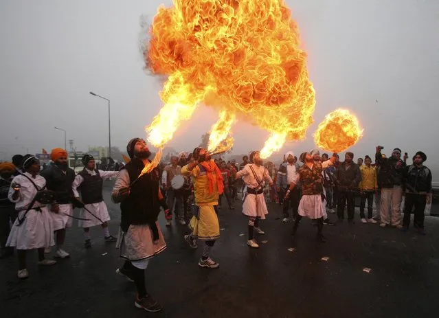 Sikh devotees show off their fire blowing skills during a religious procession ahead of the birth anniversary of Guru Gobind Singh in Jammu January 5, 2014. Guru Gobind Singh was the last and the tenth Guru of the Sikhs. (Photo by Mukesh Gupta/Reuters)