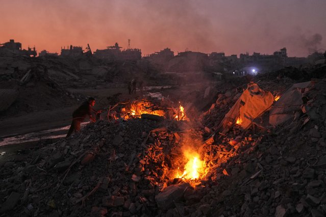 Palestinians light fires to keep away mosquitoes amid the destruction left by Israeli air and ground offensive in the Sheikh Radwan neighborhood of Gaza City, November 10, 2025. (Photo y Jehad Alshrafi/AP Photo)