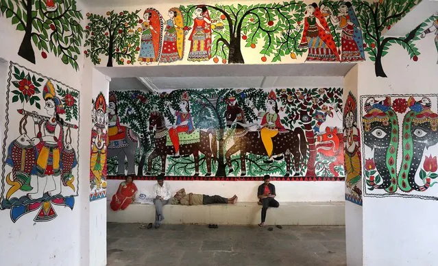 Indian people sit next to the Madhubani artworks at the Madhubani railway station in Bihar, India, 07 April 2018. (Photo by Harish Tyagi/EPA/EFE)