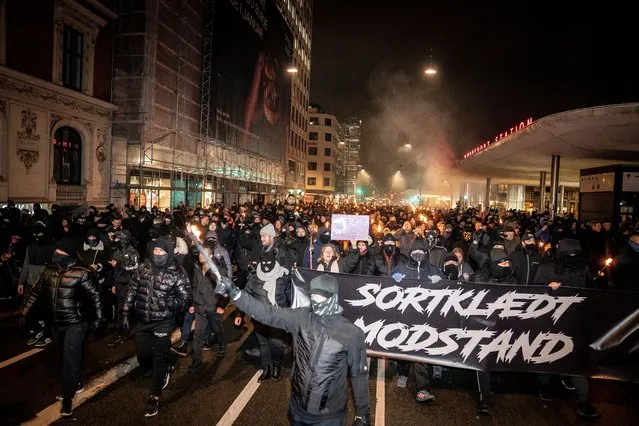 Demonstrators march with a banner reading “Black-clad resistance” during a protest march organised by radical group “Men in Black Denmark” against restrictions introduced by the Danish government during the novel coronavirus (Covid-19) pandemic, in Copenhagen on January 23, 2021. The anti-restrictions protest organized by the radical group in Copenhagen sparked new incidents late January 23, with five arrests and the burning of a model bearing the image of Prime Minister Mette Frederiksen, according to the police and local media. (Photo by Mads Claus Rasmussen/Ritzau Scanpix/AFP Photo)
