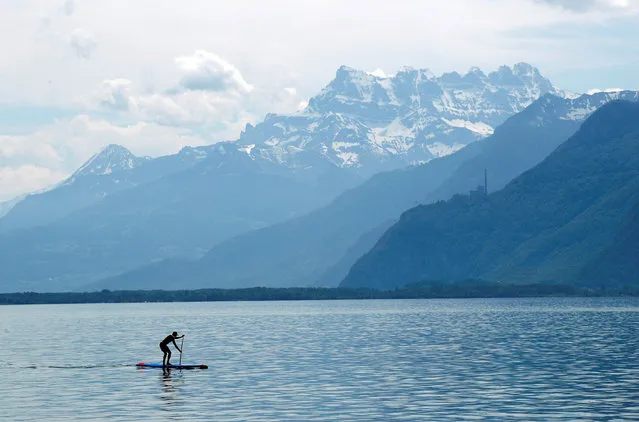 A man paddles on Lake Leman in front of the Dents-du-Midi mountains in Vevey, Switzerland, May 25, 2018. (Photo by Denis Balibouse/Reuters)