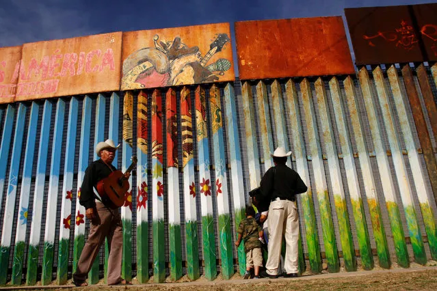 People next to musicians talk to their relatives across a fence separating Mexico and the United States, in Tijuana, Mexico, November 12, 2016. (Photo by Jorge Duenes/Reuters)