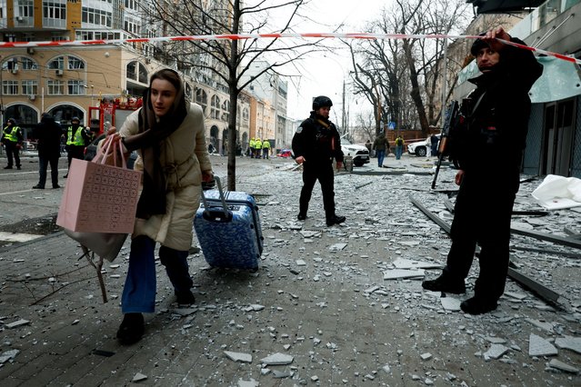 A resident leaves with her belongings from the site of a Russian missile strike, amid Russia's attack on Ukraine, in central Kyiv, Ukraine, on December 20, 2024. (Photo by Thomas Peter/Reuters)