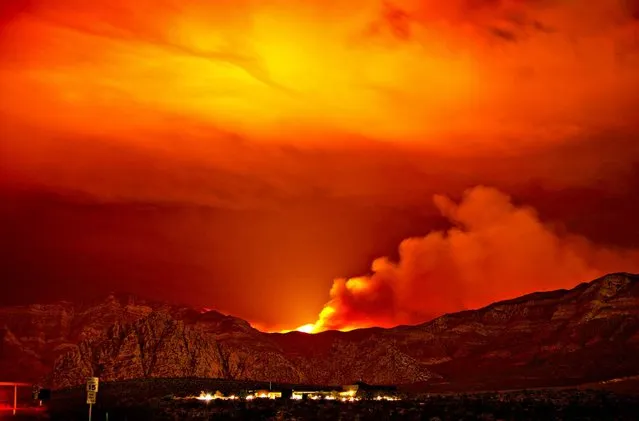The Carpenter1 fire burns in the mountains behind the Red Rock Conservation Area visitor center near Las Vegas, on July 11, 2013. The fire has forced the closure of the Red Rock National Conservation Area Scenic Loop. Firefighters hope  rain and cooler temperatures would help them corral the massive wildfire that for 10 days charred almost 44 square miles and 15 percent contained. (Photo by John Locher/Las Vegas Review-Journal)