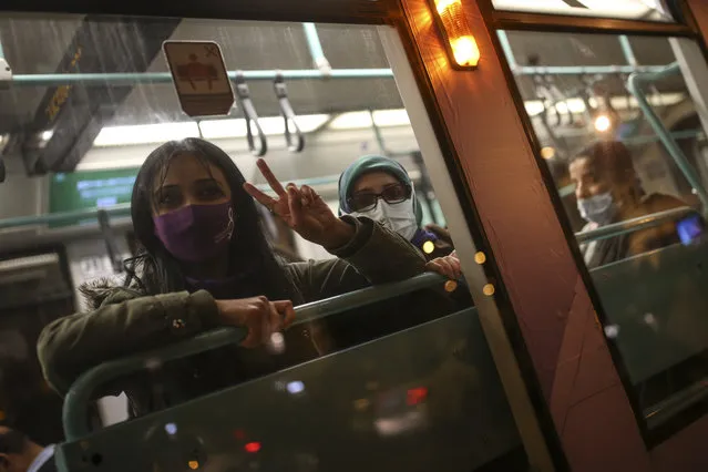 A protester flashes the V-sign from inside a bus during a rally to mark International Women's Day in Istanbul, Monday, March 8, 2021.Thousands of people joined the march to denounce violence against women in Turkey, where more than 400 women were killed last year. The demonstrators are demanding strong measures to stop attacks on women by former partners or family members as well as government commitment to a European treaty on combatting violence against women. (Photo by Emrah Gurel/AP Photo)