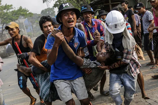 An injured demonstrator is carried to receive medical attention during a protest against the military coup in Hlaingthaya (Hlaing Tharyar) Township, outskirts of Yangon, Myanmar, 14 March 2021. Anti-coup protests continued despite the intensifying violent crackdowns on demonstrators by security forces. (Photo by EPA/EFE/Stringer)