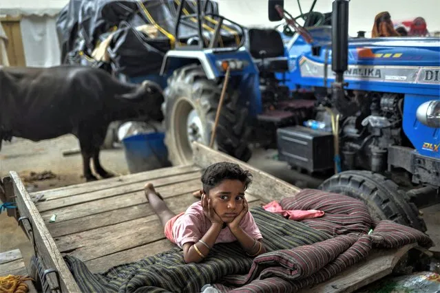A boy displaced by the rising waters of the river Yamuna lies on a rickshaw outside a makeshift shelter on a road side, in New Delhi, India on July 15, 2023. (Photo by Adnan Abidi/Reuters)
