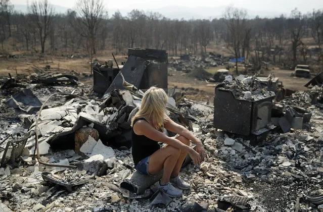 Diana Hartman sits while helping to sift through the charred remains of her mother-in-law's home that was burned in the Carr Fire, Saturday, August 11, 2018, in Redding, Calif. (Photo by John Locher/AP Photo)
