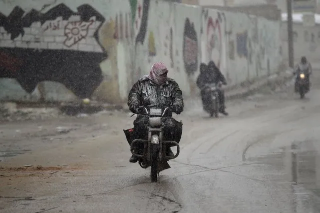 Men drive motorcycles during a snowstorm in Jabal al-Zawiya, in the southern countryside of Idlib, Syria January 1, 2015. (Photo by Khalil Ashawi/Reuters)