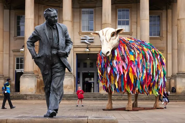 Aina the mother sheep, a 4.5-metre musical sculpture installed in the first decade of July 2023 outside Huddersfield railway station in England as part of Artichoke’s latest project, Herd. She is one of 23 giant handcrafted musical sheep that will appear all over Kirklees this week before joining Aina for a grand finale in Huddersfield on 16 July. (Photo by Christopher Thomond/The Guardian)