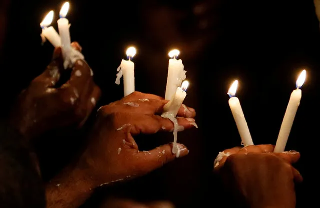 Supporters of the former Sri Lankan President Mahinda Rajapaksa, who leads the country's joint opposition, hold candles during an anti-government protest in Colombo, Sri Lanka on September 5, 2018. (Photo by Dinuka Liyanawatte/Reuters)