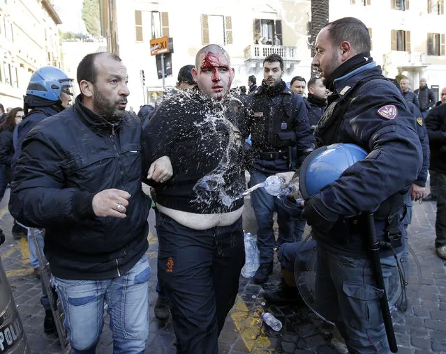 An injured Feyenoord's fan is carried away after being arrested during clashes occurred with Italian policemen at the Spanish steeps prior to the start of the Europa League soccer match between Roma and Feyenoord in Rome, Thursday, February 19, 2015. (Photo by Gregorio Borgia/AP Photo)