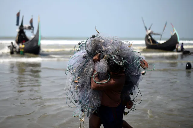 A Rohingya refugee carries fishing net on Shamlapur beach in Cox's Bazaar, Bangladesh, March 22, 2018. (Photo by Clodagh Kilcoyne/Reuters)