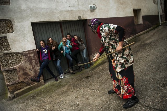 In this photo taken on Sunday, February 15, 2015 a group of young girls react next to a “Mamuxarro” during the carnival, in the small town of Unanu, northern Spain. (Photo by Alvaro Barrientos/AP Photo)