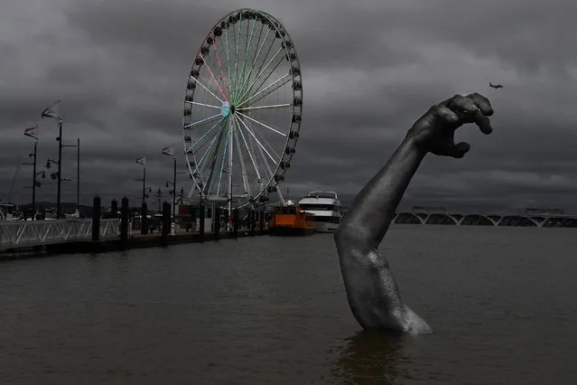A portion of the statue “The Awakening” is submerged by rising waters at National Harbor in Oxon Hill, Md. on September 9, 2018. (Photo by Matt McClain/The Washington Post)