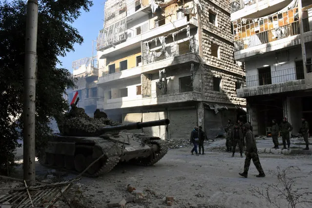 Forces loyal to Syria's President Bashar al-Assad stand near a tank in a government held area of Aleppo, Syria, in this handout picture provided by SANA on December 8, 2016. (Photo by Reuters/SANA)
