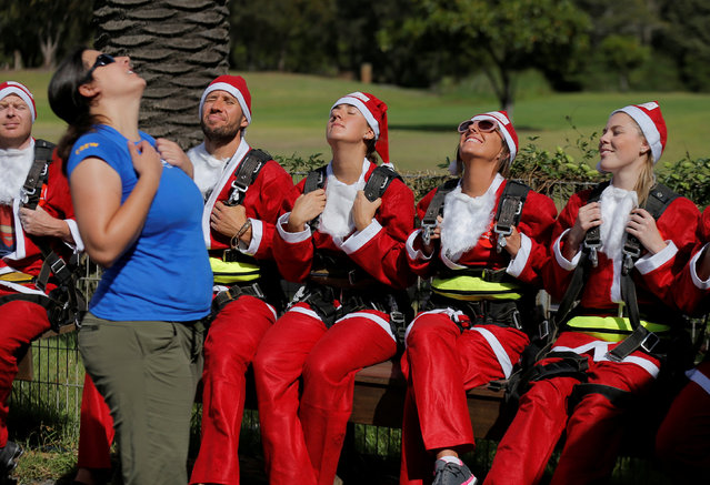 Skydivers dressed in Santa Claus outfits rehearse their procedure before breaking the Guinness World Record number of tandem skydives over eight hours, setting a new record of 155 skydives, in the Australian city of Wollongong, December 17, 2016. (Photo by Jason Reed/Reuters)