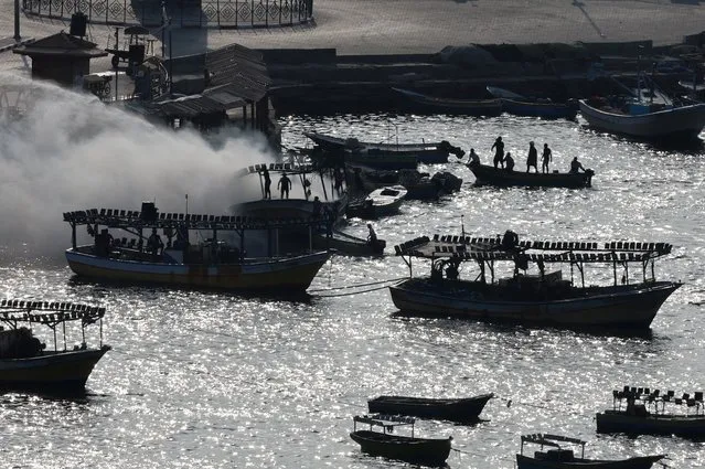 Smoke billows from a boat following Israeli strikes, at the seaport of Gaza City on October 8, 2023. (Photo by Mohammed Salem/Reuters)