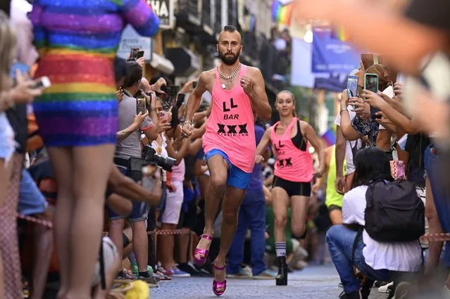 A participant takes part in the High-Heels Race as part of the Pride celebrations, in the Chueca neighbourhood in Madrid on July 7, 2022. MADO (Madrid Pride) is a series of street celebrations that take place during the city's LGBTIQ (lesbian, gay, bisexual, transgender, intersеx and queer) Pride week. The Pride parade on July 9 will be the highlight of the week. (Photo by Javier Soriano/AFP Photo)
