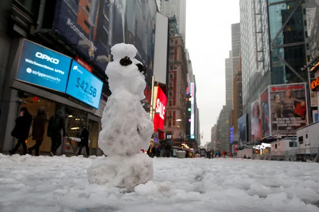 A snowman stands in Times Square following a morning snow in Manhattan, New York City, U.S. December 17, 2016. (Photo by Andrew Kelly/Reuters)
