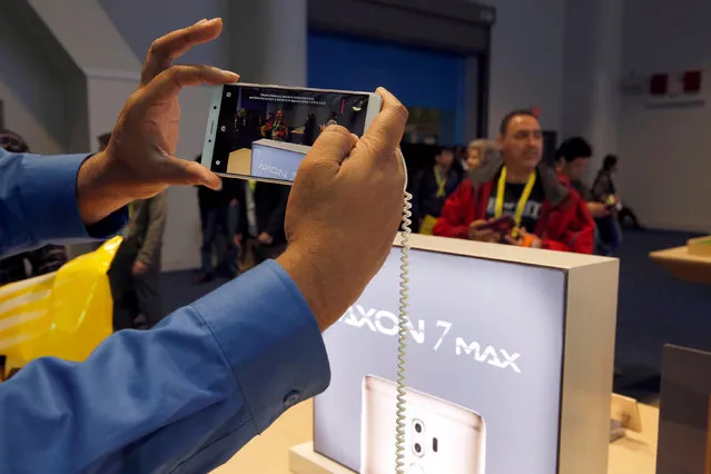 A man takes a photo with an Axon 7 Max smartphone with 3D camera at the ZTE booth during the 2017 CES in Las Vegas, Nevada January 6, 2017. (Photo by Steve Marcus/Reuters)