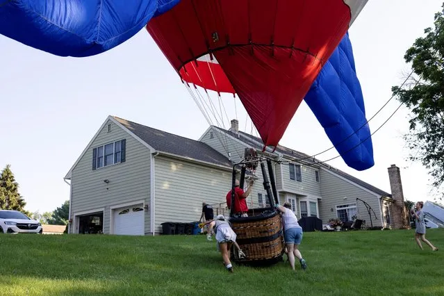 A hot air balloon lands in a residential area during the New Jersey Lottery Festival of Ballooning in Flemington, New Jersey, U.S., July 24, 2021. (Photo by Hannah Beier/Reuters)