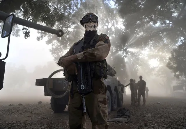 A French soldier wearing a skeleton mask stands next to a tank in a street in Niono, on January 20, 2013. (Photo by Issouf Sanogo/AFP Photo)
