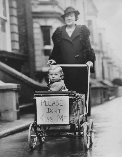 To prevent friends and relatives from kissing her baby, this woman has attached this card to the front of her stroller in order to safeguard her child against infectious colds, Margate, England, early to mid 20th century. (Photo by Visual Studies Workshop/Getty Images)