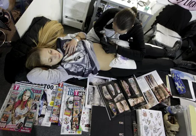An artist draws a tattoo on a woman's belly during a tattoo convention in Ljubljana April 18, 2015. (Photo by Srdjan Zivulovic/Reuters)