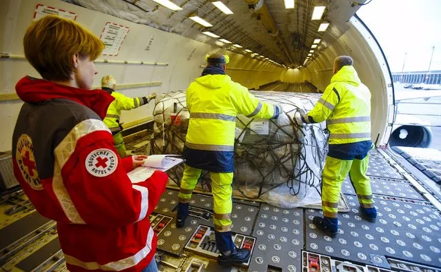 Workers load humanitarian aid from German Red Cross (DRK) for victims of the earthquake in Nepal, into an aircraft at Schoenefeld airport outside Berlin April 27, 2015. (Photo by Hannibal Hanschke/Reuters)