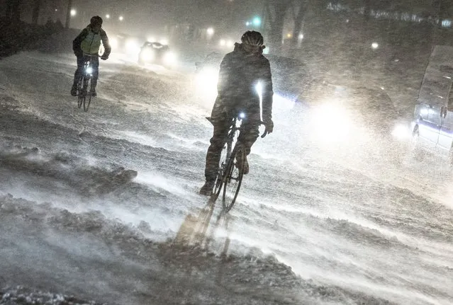 A person on a bicycle drives on a street during heavy snowfall in Aalborg, northern Jutland, Denmark, Wednesday, January 3, 2024. Temperatures have fallen below minus 40 degrees Celsius in the Nordic region for a second day in a row, with the coldest January temperature recorded in Sweden in 25 years as a cold spell grips the area. (Photo by Henning Bagger/Ritzau Scanpix via AFP Photo)