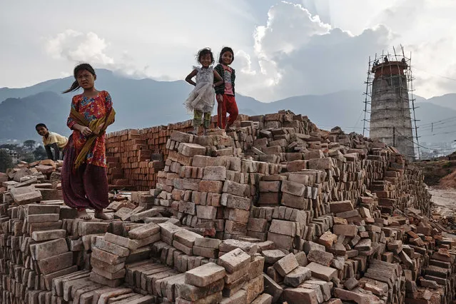 Child labourers pose for a photo atop a mound of bricks in Kathmandu Valley, Nepal, 25 October 2015. (Photo by Jan Moeller Hansen/Barcroft Images)